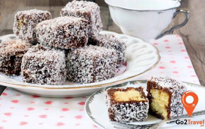 bánh Lamington hình vuông được phủ đầy chocolate và dừa nạo