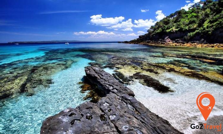 bờ biển sóng vỗ nhẹ nhàng vào bãi cát trắng mịn trải dài