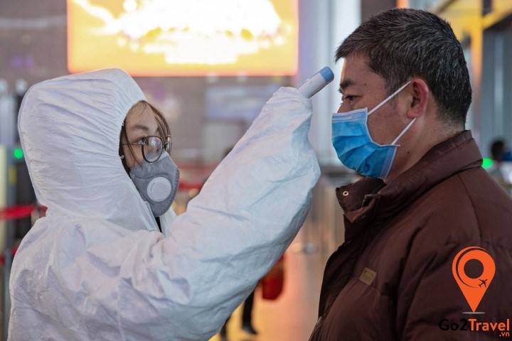 bác sĩ đang kiểm tra thân nhiệt của bệnh nhân nghi nhiễm corona